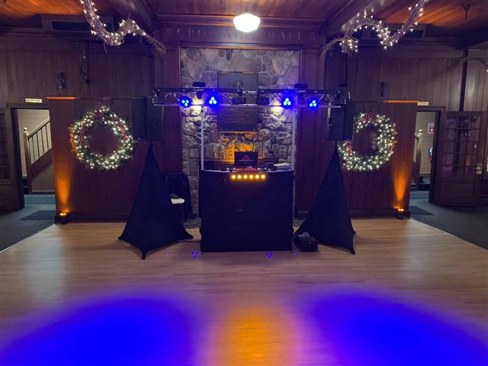 Holiday-decorated venue with DJ setup and wreaths