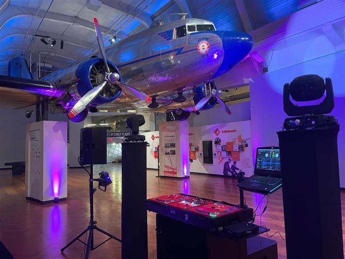 DJ setup inside an aircraft hangar museum event space